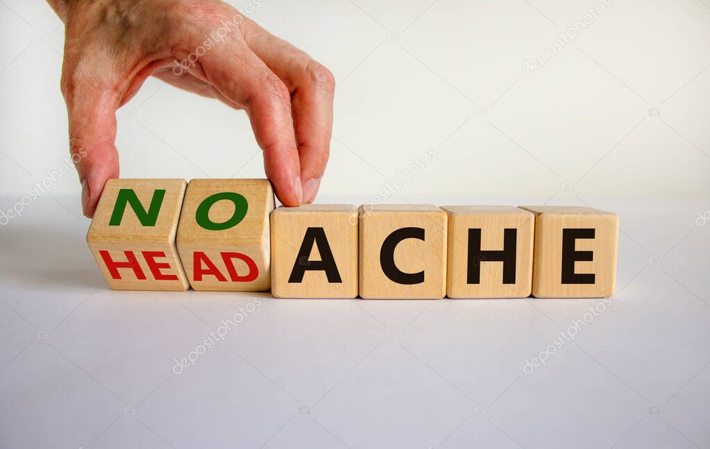 Male hand flips wooden cubes and changes the inscription 'headache' to 'no ache'. Beautiful white background, copy space. Medical concept.