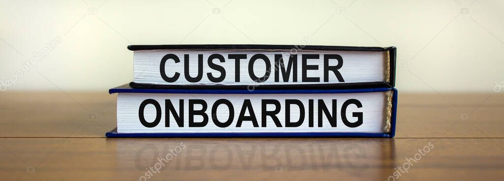 Books with text 'customer onboarding' on beautiful wooden table. White background. Business concept. Copy space.