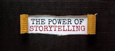 'Hikaye anlatmanın gücü' sözcüğü yırtık siyah kağıdın arkasında beliriyor. Güzel arka plan. İş konsepti.