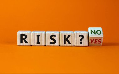 Risk hakkında bir soru. Tahta bir küp çevirdim ve 'risk evet' yazısını 'risk hayır' a çevirdim. Güzel turuncu arkaplan, kopyalama alanı. İş konsepti.