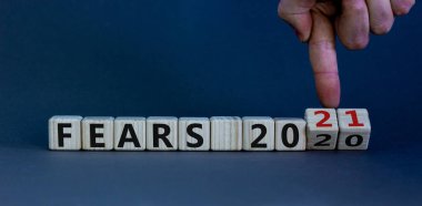 İş planı 2021. Erkek el ahşap küpleri çevirir ve '2020 Korkusu' yazısını '2021 Korkusu' olarak değiştirir. Güzel gri arkaplan, kopyalama alanı.