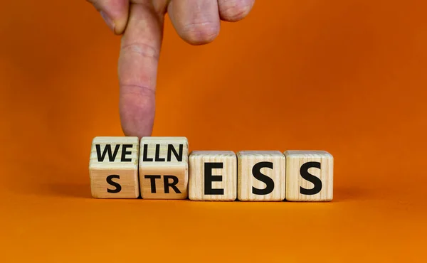 ストレスではなく健康 手はキューブを回し ストレス という言葉を ウェルネス に変えます 美しいオレンジの背景 コンセプト スペースのコピー — ストック写真