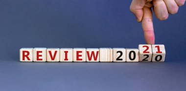 İş konsepti 2021 'de başlıyor. Yand tahta küpleri çeviriyor ve '2020 Gözden Geçir' kelimesini '2021 Gözden Geçir' olarak değiştiriyor. Güzel gri arkaplan, kopyalama alanı.