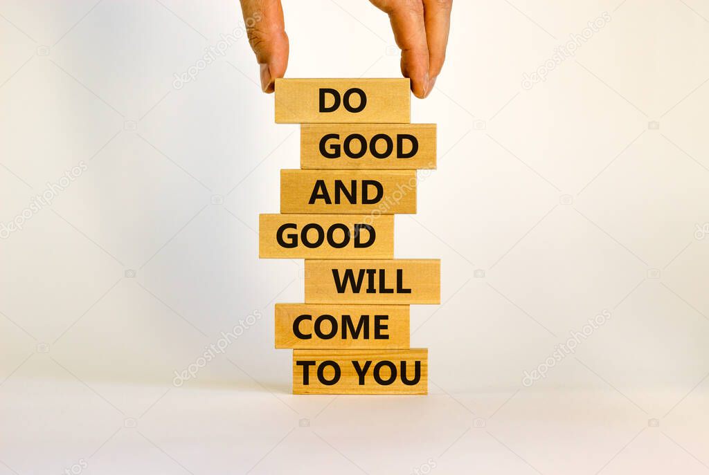 Concept of karma motivational words. Wooden blocks on the stack of wooden blocks. Words 'do good and good will come to you'. Beautiful white background, copy space.