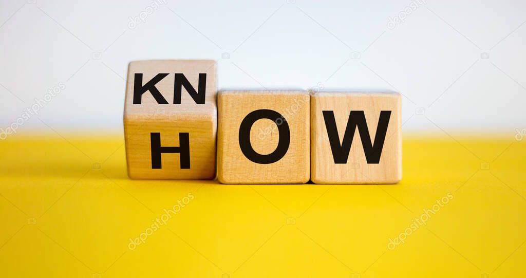 Know how and business concept. Turned cube and changed the word 'how' to 'know'. Beautiful yellow table, white background. Copy space.