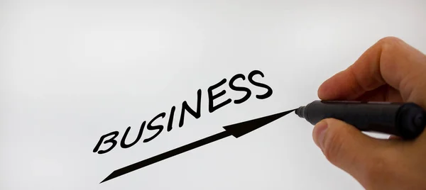 Business concept growth success process. Male hand with black marker writing word business and up arrow. Beautiful white background, copy space.