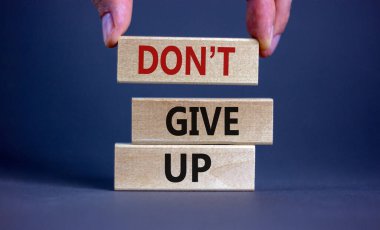 Do not give up symbol. Wooden blocks with words 'do not give up'. Beautiful grey background. Copy space. Business, motivational and do not give up concept.