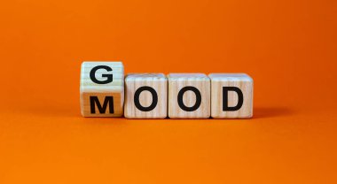 Good mood symbol. Fliped a wooden cube and changed the word 'good' to 'mood'. Beautiful orange background, copy space. Business and good mood concept.
