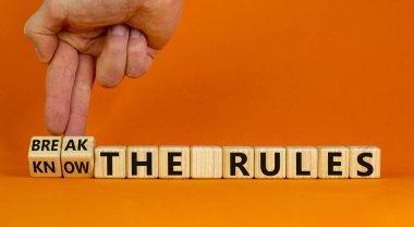 Kuralları bil ve çiğne. El küplere dönüşür ve 'kuralları bil' ve 'kuralları çiğne' kelimelerini değiştirir. Güzel turuncu arka plan. İş ve kural kavramını bilmek. Boşluğu kopyala.