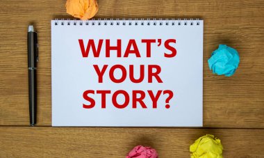 Your story symbol. White note with inscription 'what is your story' on beautiful wooden table, colored paper, metalic pen, drawn light bulb and wrench. Business and your story concept.
