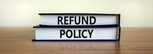 Refund policy symbol. Books with words \'Refund policy\' on beautiful wooden table. White background. Business and refund policy concept.