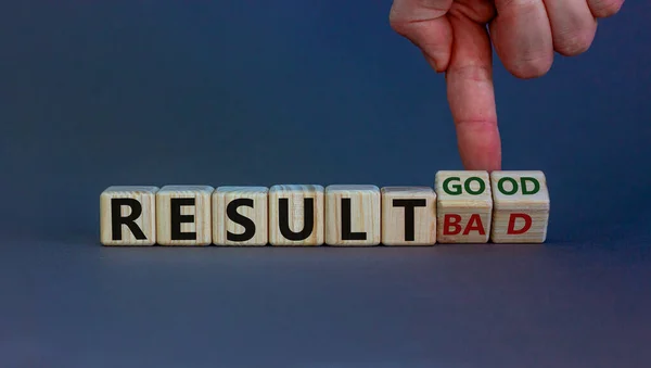 Good or bad result symbol. Hand turns cubes and changes words 'result bad' to 'result good'. Beautiful grey background. Business and good result concept, copy space.