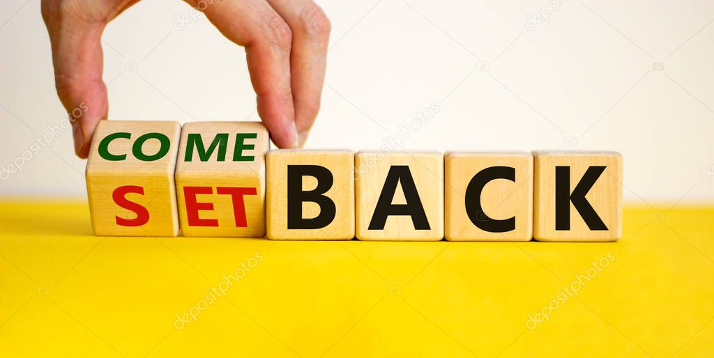 Setback or comeback symbol. Male hand flips wooden cubes and changes the word 'setback' to 'comeback'. Beautiful yellow and white background, copy space. Business and comeback concept.