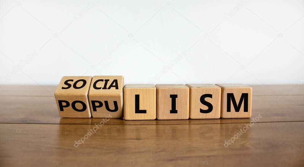 Populism or socialism. Turned cubes and changed word 'socialism' to 'populism'. Beautiful wooden table, white background, copy space. Business and populism or socialism concept.