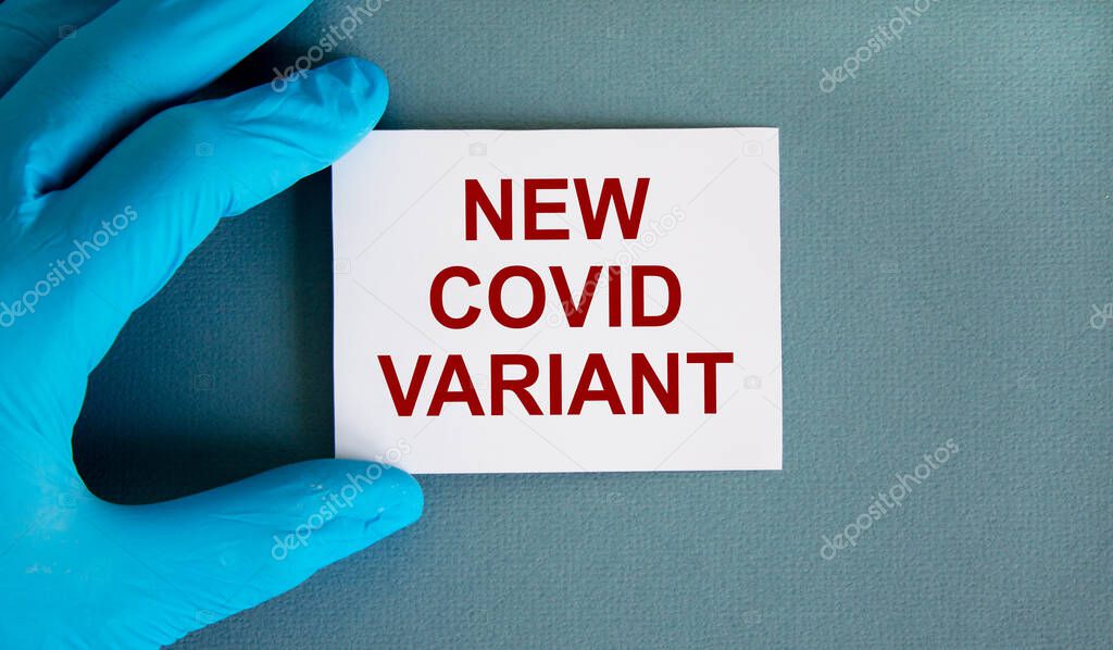 New covid variant symbol. Hand in blue glove with white card. Concept words 'New covid variant'. Medical and COVID-19 pandemic concept. Copy space.