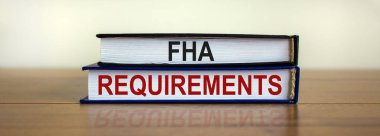 FHA gereksinim sembolü. Güzel ahşap masada 'FHA gereksinimleri' yazılı kitaplar. Beyaz arka plan. İş ve FHA - federal konut yönetimi kavramı.