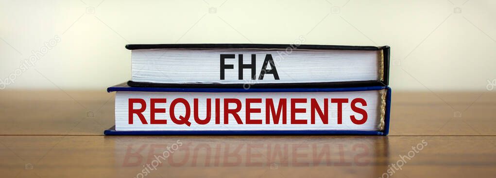 FHA requirements symbol. Books with words 'FHA requirements' on beautiful wooden table. White background. Business and FHA - federal housing administration concept.
