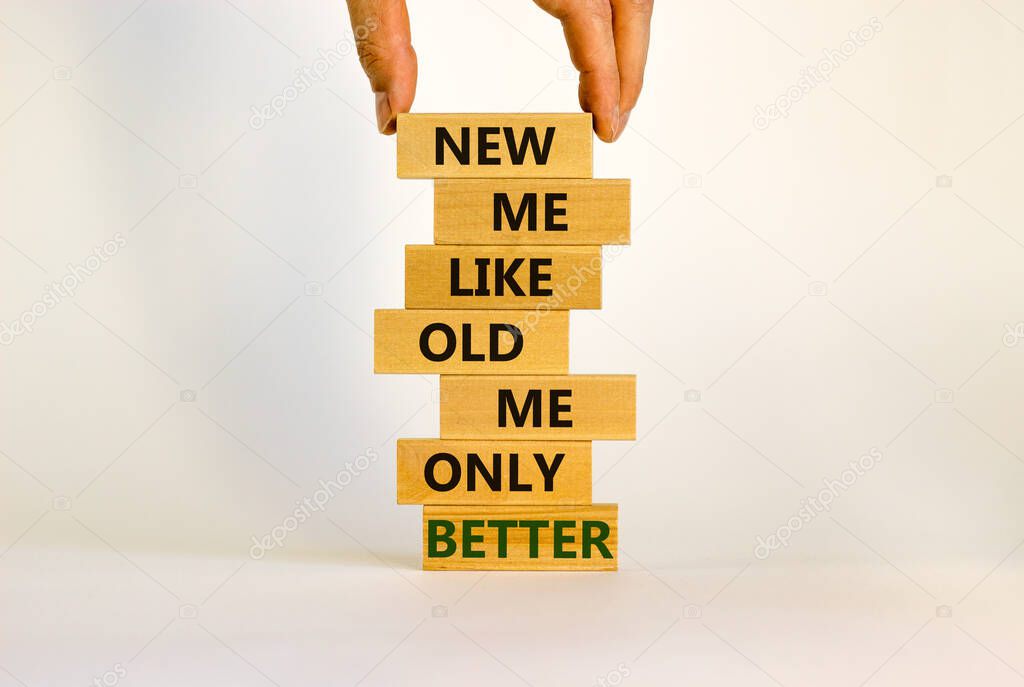 Concept of building success foundation. Men hand put wooden blocks on the stack of wooden blocks. Words 'new me like old me only better'. Beautiful white background, copy space. New me symbol.