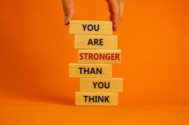 Sandığından daha güçlüsün. Erkek eli. Tahta bloklar kulesinin üzerinde 