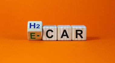 Elektrikli araba ya da hidrojen arabası. Küpü çevirdim ve 'H2 car' kelimesini 'E-car' a çevirdim. Güzel turuncu arkaplan, kopyalama alanı. İş ve elektrik veya H2 hidrojen otomobil kavramı.