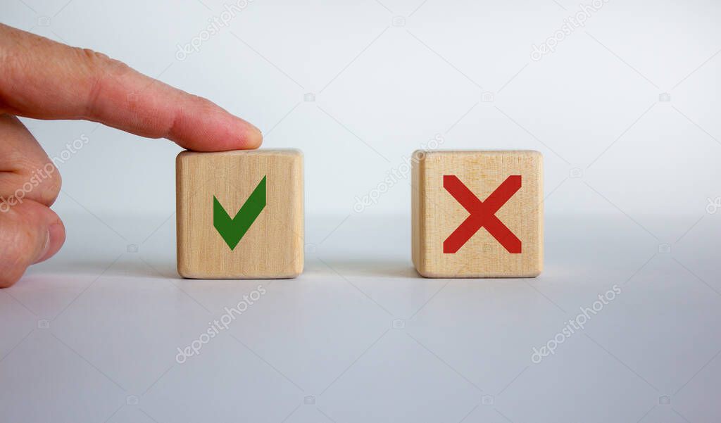 Yes or no choice symbol. Hand making a choice between two cubes with Yes and No icon on beautiful neutral white background. Business and yes or no choice concept. Copy space.