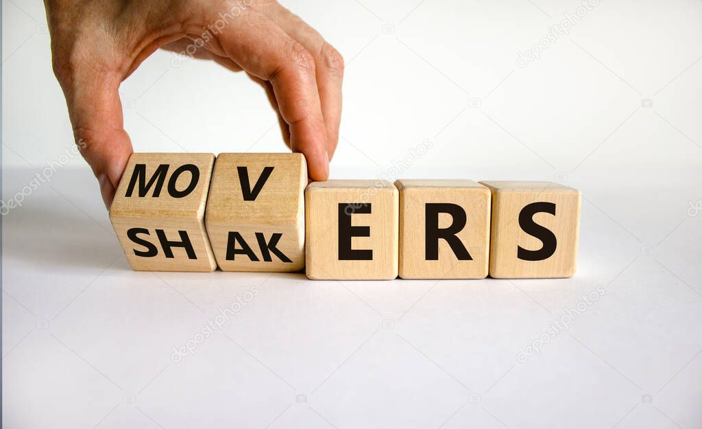 Movers and Shakers symbol. Businessman hand turns cubes and changes the word 'shakers' to 'movers'. Beautiful white background. Business and Movers and Shakers concept. Copy space.