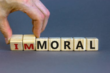 Ahlak ya da ahlaksızlık sembolü. El küpleri döndürür ve 'ahlaksız' kelimesini 'ahlaksız' a çevirir. Güzel gri arkaplan. İş ve ahlak ya da ahlak dışı kavramlar. Boşluğu kopyala.