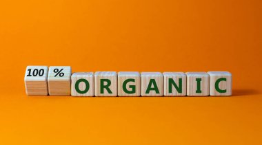 Yüzde yüz organik sembol. Tahta küpleri çevirdim ve 'organik' ile '% 100 organik' kelimelerini değiştirdim. Güzel turuncu arkaplan, kopyalama alanı. İş, sağlıklı yaşam tarzı organik konsept.