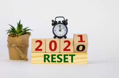 İş ve 2021 yeni yıl sembolü sıfırlandı. Tahta küpü çevirdim ve '2020' yi sıfırla 'yı' 2021 'e sıfırla. Çalar saat, bitki. Güzel beyaz arka plan, kopyalama alanı. İş sıfırlama kavramı.