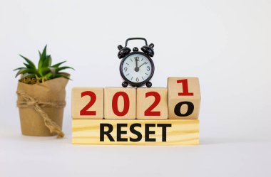 İş ve 2021 yeni yıl sembolü sıfırlandı. Tahta küpü çevirdim ve '2020' yi sıfırla 'yı' 2021 'e sıfırla. Çalar saat, bitki. Güzel beyaz arka plan, kopyalama alanı. İş sıfırlama kavramı.