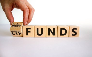 Endeks fonları ETF sembolüne karşı. İşadamı küpü çeviriyor ve kelimeleri 'ETF' olarak değiştiriyor. Güzel beyaz arka plan, kopyalama alanı. İş ve ETF ve endeks fonları kavramı.