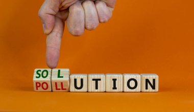 Kirlilik sembolünün çözümü. Erkek eli ahşap küpleri çevirir ve 'kirlilik' kelimesini 'çözüm' olarak değiştirir. Güzel turuncu arkaplan, kopyalama alanı. İş, ekolojik ve kirlilik kavramı.