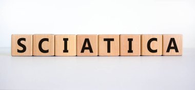 Siyatik sembolü. 'Siyatik' kelimeli tahta küpler. Güzel beyaz arka plan. Tıbbi ve siyatik konsepti. Boşluğu kopyala.