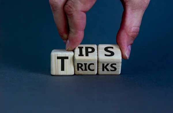 Tips and tricks symbol. Businessman turns cubes and changes the word \'tricks\' to \'tips\'. Beautiful grey background. Business, tips and tricks concept. Copy space.