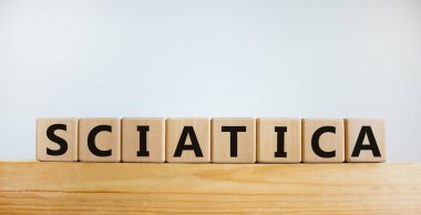 Siyatik sembolü. 'Siyatik' kelimeli tahta küpler. Güzel beyaz arka plan. Tıbbi ve siyatik konsepti. Boşluğu kopyala.