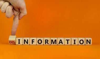 Bilgi ya da yanlış bilgilendirme sembolü. İşadamı küpü çeviriyor ve yanlış bilgilendirme kelimesini bilgiye çeviriyor. Turuncu arkaplan, kopyalama alanı. İş ve bilgi veya yanlış bilgilendirme kavramı.