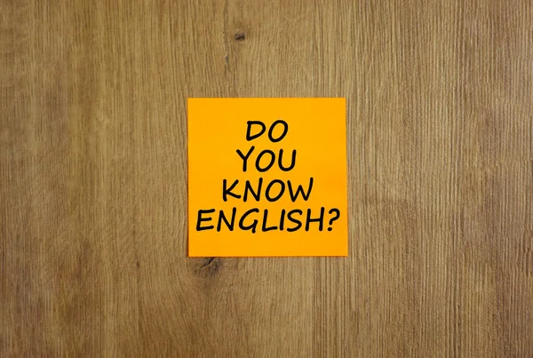 Do you know english symbol. Yellow sheet of paper. Words \'Do you know english\'. Beautiful wooden background. Business, education and do you know english concept, copy space.