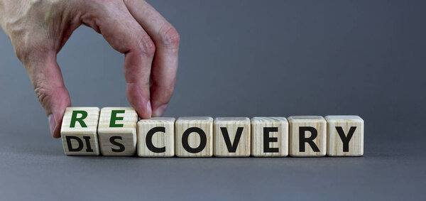 Recovery or discovery symbol. Businessman turns wooden cubes, changes a word 'discovery' to 'recovery'. Beautiful grey background. Business and discovery or recovery concept. Copy space.