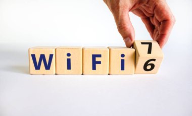 Wi-Fi 6 ya da 7 sembolü. İşadamı tahta küpü çeviriyor ve Wi-Fi 6 'yı WiFi 7' ye çeviriyor. Güzel beyaz arka plan, kopyalama alanı. İş, teknoloji ve WiFi 6 'dan WiFi 7 konseptine.