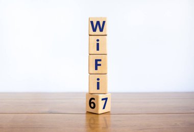 Wi-Fi 6 ya da 7 sembolü. Tahta bir küp yaptı ve Wi-Fi 6 'yı WiFi 7' ye çevirdi. Güzel ahşap masa, beyaz arka plan, fotokopi alanı. İş, teknoloji ve WiFi 6 'dan WiFi 7 konseptine.