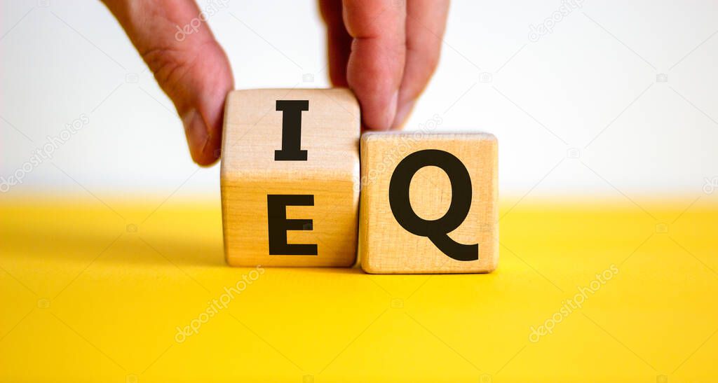 IQ or EQ symbol. Psychologist flips a cube, changes words IQ, intelligence quotient to EQ, emotional quotient. Beautiful white background. Concept of emotional and intelligence quotient. Copy space.
