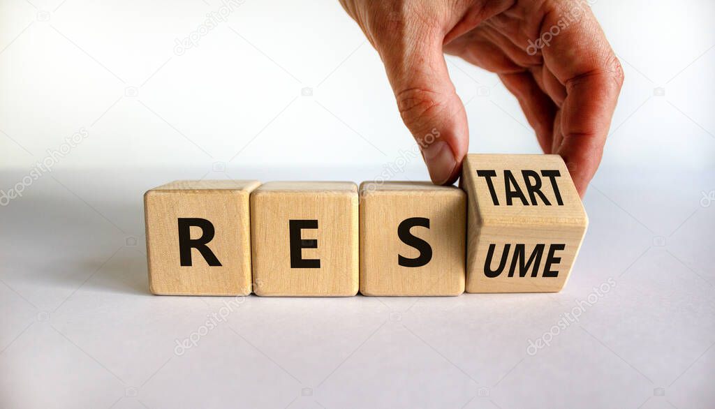 Resume and restart symbol. Businessman hand turns cubes and changes the word 'resume' to 'restart'. Beautiful white background. Business and resume - restart concept. Copy space.