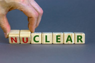 Nükleer ya da açık bir sembol. İşadamı küpü çevirir ve 'nükleer' kelimesini 'temiz' olarak değiştirir. Güzel gri arkaplan. Nükleer ya da temiz ve iş konsepti. Boşluğu kopyala.