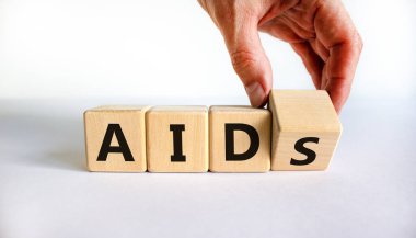 AIDS 'li insanlara yardım etmenin sembolü, kazanılmış bağışıklık yetmezliği sendromu. Doktor, kelimelerin yardımı ile tahta küpü çevirir. Güzel beyaz arka plan, kopyalama alanı. Tıbbi ve AİDS yardım kavramı.