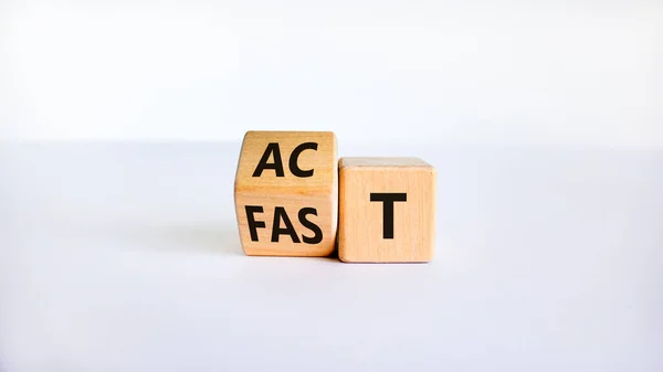 Time to act fast symbol. Turned a wooden cube with words \'act fast\'. Beautiful white table, white background, copy space. Business and act fast concept.