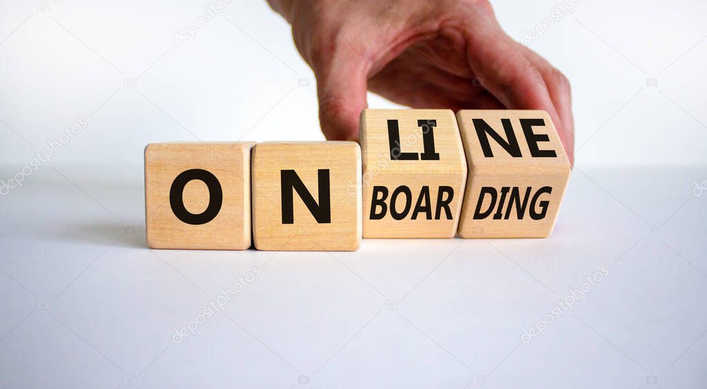 Online onboarding symbol. Businessman turns wooden cubes with words 'online onboarding'. Beautiful white table, white background, copy space. Business, online onboarding concept.