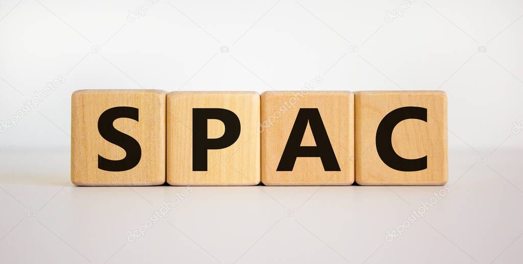 SPAC, special purpose acquisition company symbol. Wooden cubes with word 'SPAC' on beautiful white background, copy space. Business and SPAC, special purpose acquisition company concept.