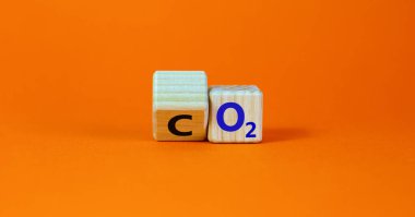 Karbondioksit veya oksijen sembolü. Tahta küpü çevirdim ve 'CO2, karbondioksit', 'O2, oksijen' kelimelerini değiştirdim. Güzel turuncu arkaplan, kopyalama alanı. İş, ekolojik ve karbon nötr kavram.