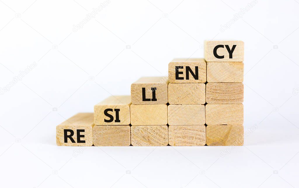 Resiliency symbol. Wooden blocks with word 'resiliency' stacking as step stair on beautiful white background, copy space. Business and resiliency concept success process.
