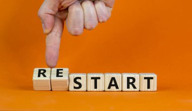 Sembolü başlat veya yeniden başlat. İşadamı ahşap küpleri değiştiriyor ve 